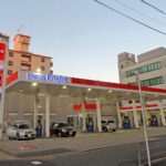 pompistes effectuant le rituel du plein d essence au Japon dans une station service Eneos