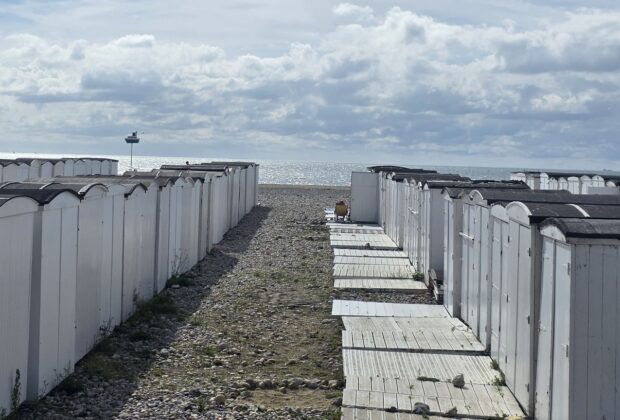 Alignement de cabanes blanches sur la plage de galets du Havre
