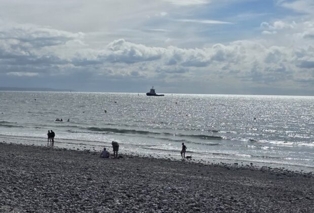 Promeneurs sur la plage de galets face à la mer au Havre