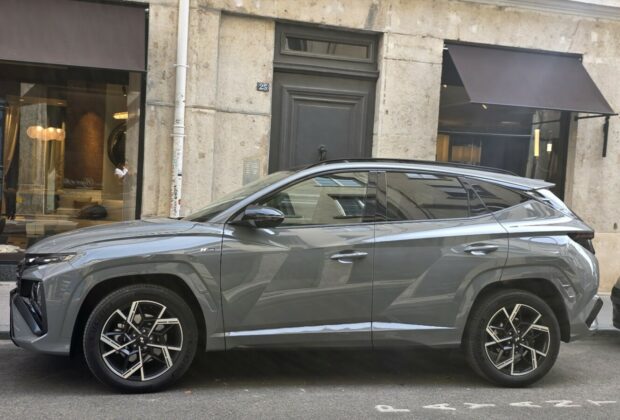 Hyundai Tucson Hybrid gris photographié de profil dans une rue de Lyon.