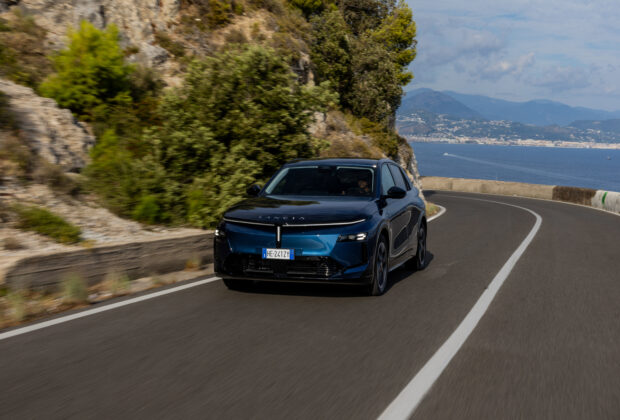 Lancia Gamma bleue en mouvement sur une route côtière sinueuse de Campanie